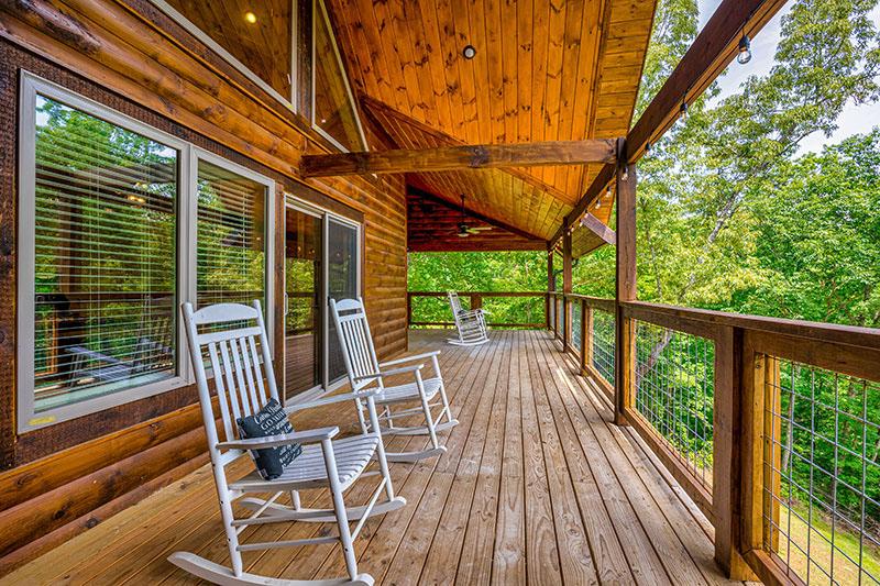 Enjoy your large cabin porch in a wooded setting.   at Big Splash Lodge in Gatlinburg TN