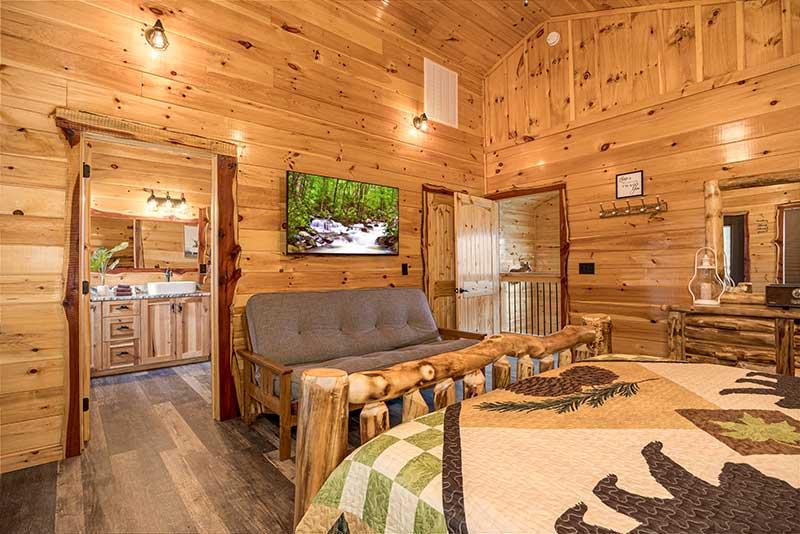 Cabin master bedroom with tv and futon seating. at Sunset Peak in Gatlinburg TN