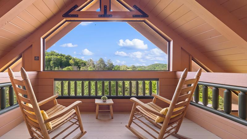 Smoky Mountains enclosed cabin porch with rockers. at Moonlight Pines Lodge in Gatlinburg TN