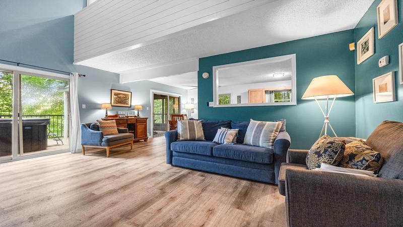 Your relaxing Gatlinburg chalet's living room with large glass doors looking out over a forest setting. at Chalet All Day in Gatlinburg TN