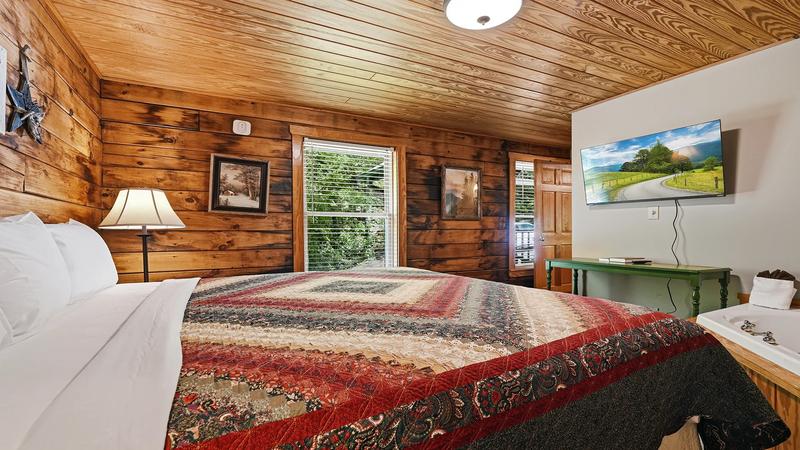 Cabin First Bedroom With TV Catch up on your shows relaxing on a kig size bed.
