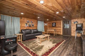 Roomy cabin game room with fireplace and big tv. at Moonlight Obsession in Gatlinburg TN