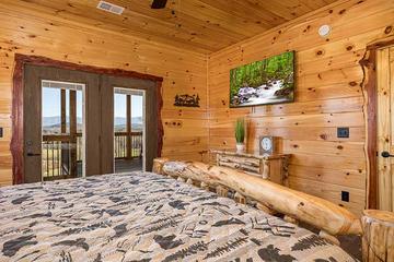 Enjoy late night tv and sunsets from your log bed. at Sunset Peak in Gatlinburg TN