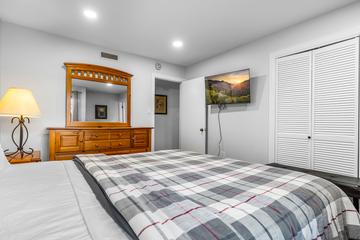 First Bedroom With TV Watch favorite shows while relaxing in your king bed.